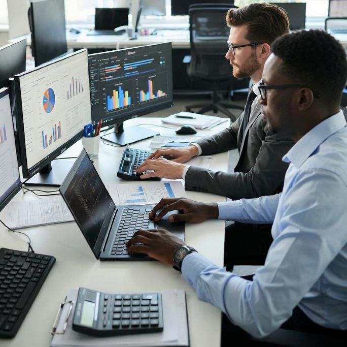Modern financial professionals analyzing data on laptops